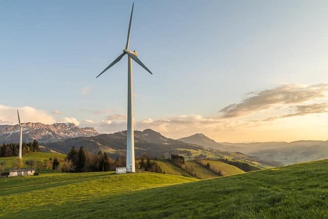 Dans la page A propos .Deux éoliennes plantées sur une colline dans un paysage montagneux