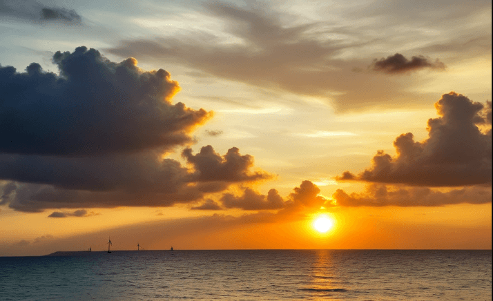 La sobriété énergétique représentée par un soleil couchant au bord de la mer