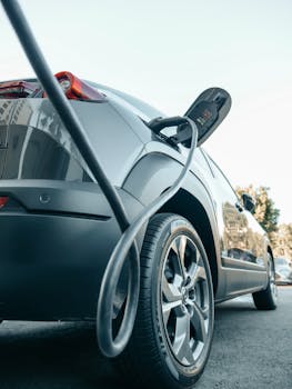 Close-up of an electric car charging at a modern charging station, showcasing clean energy technology.