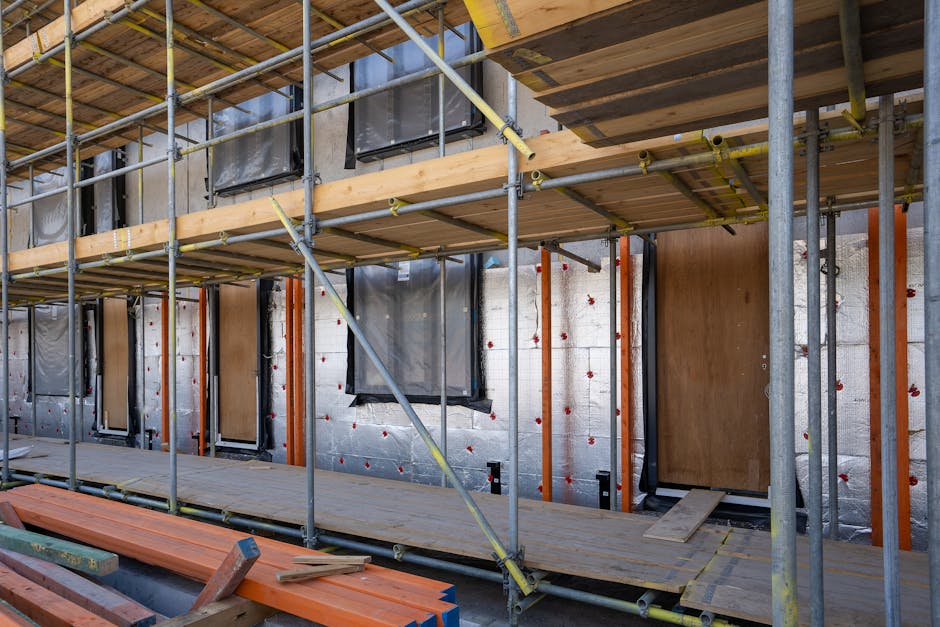 Scaffolding at a residential building under construction with windows and insulation sheets visible. dans la page rénovation